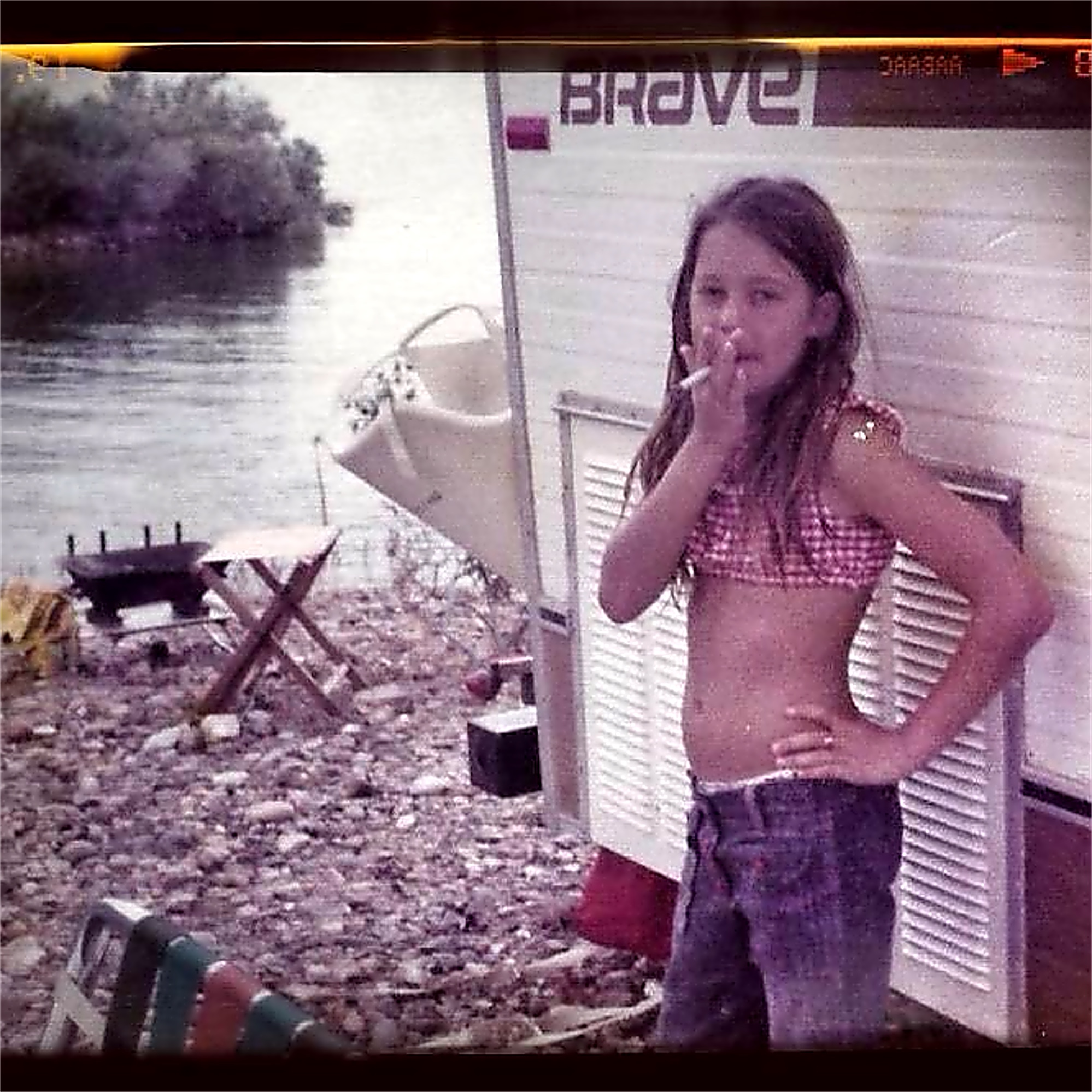 A candid vintage photo of Tanya Brooking by a lakeside camper